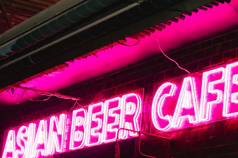 The pink Asian Beer Cafe neon sign glowing at night
