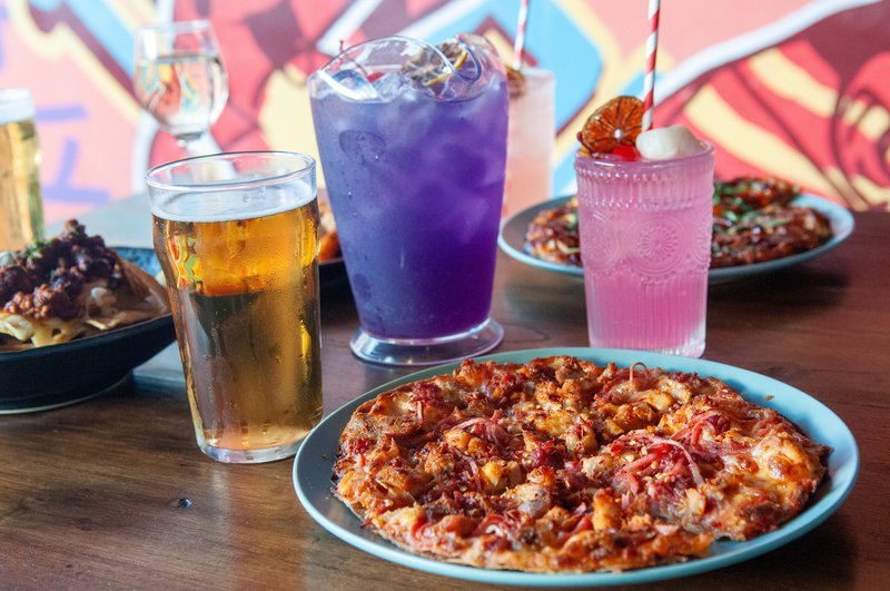 Pizza, a beer and colourful cocktails in front of the street-art wall