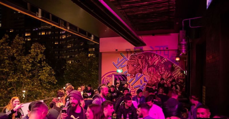 A packed balcony party at night, Asian Beer Cafe