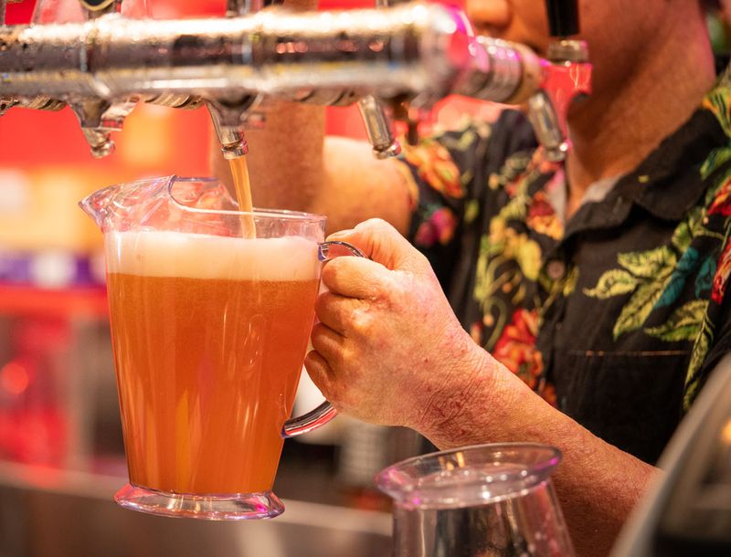 A bartender pouring a jug of beer at the Asian Beer Cafe taps