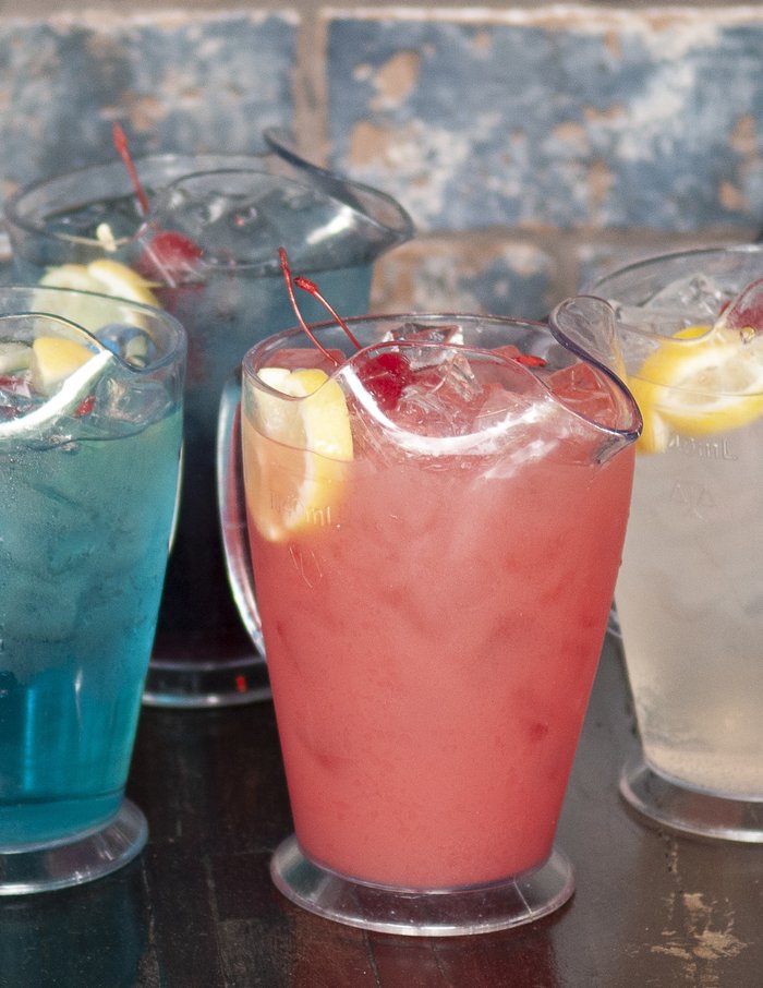 A row of colourful cocktails on the bar