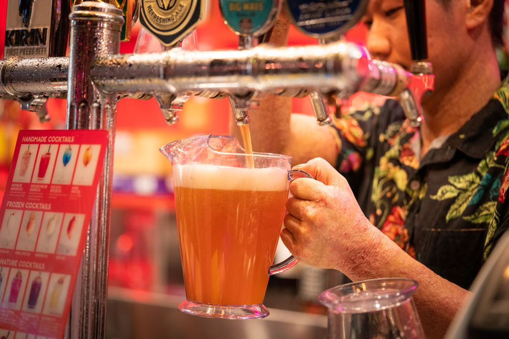 A bartender pouring a jug of beer
