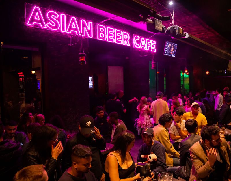 A full room under the Asian Beer Cafe neon sign